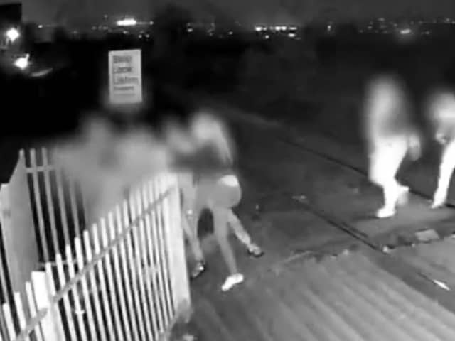 Men hold shut gates of level crossing in Barnsley, South Yorkshire.