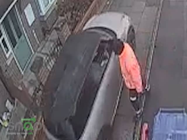 Car drives along pavement to get past bin lorry.