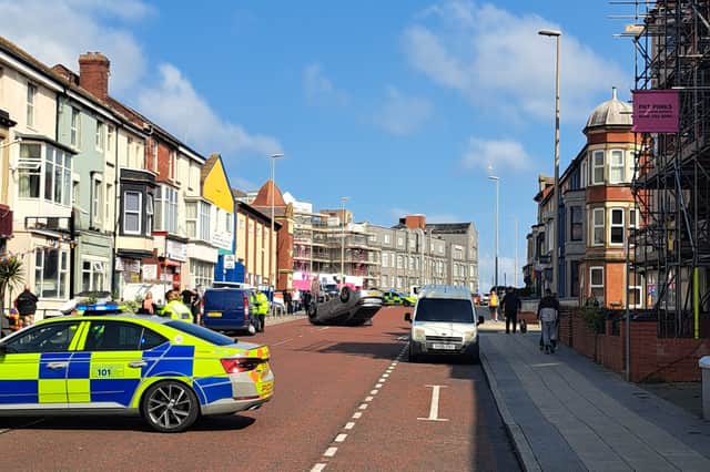 A car upside down on Dickson Road, Blackpool at 10:00 am this morning, surrounded by police cars.