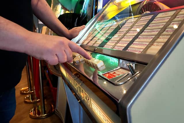Karl Dawson picks a song on a Ditchburn Jukebox, in his St Anne's cafe. Video by Lucinda Herbert.