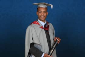 Clarke Carlisle holding his Honorary Fellowship from the University of Central Lancashire.