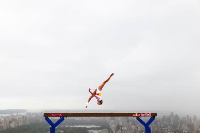 Thrill-seeking athlete Lily Smith has performed a daring balance beam routine 52 stories above street level.