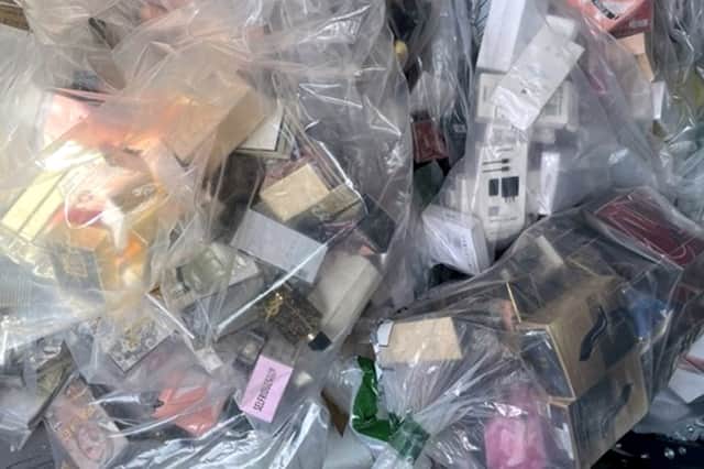 Hundreds of suspected fake perfume bottles and scores of suspected illicit Apple and Samsung products have been uncovered by Trading Standards at Norcross Car Boot