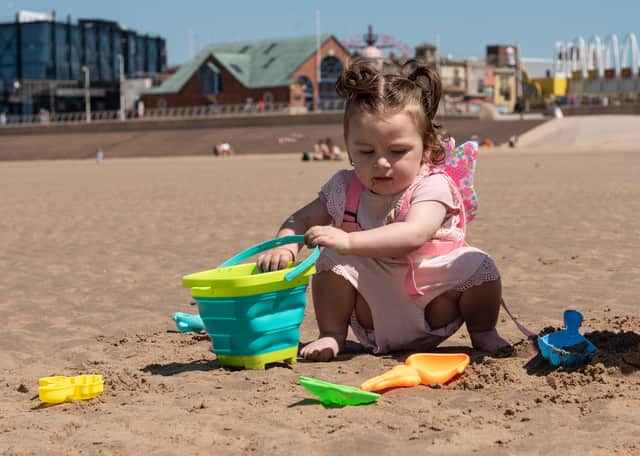 A litte girl builds sandcastles on Blackpool beach. Photo: Lucinda Herbert