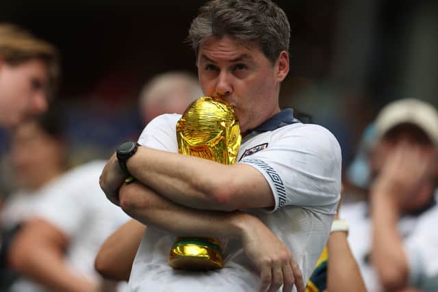 An English fan kisses a replica of the World Cup trophy ahead of the 2026 World Cup football tournament quarter-final match between Norway and England at Miami Stadium in Miami Gardens on 11 July 2026.