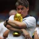 An English fan kisses a replica of the World Cup trophy ahead of the 2026 World Cup football tournament quarter-final match between Norway and England at Miami Stadium in Miami Gardens on 11 July 2026.