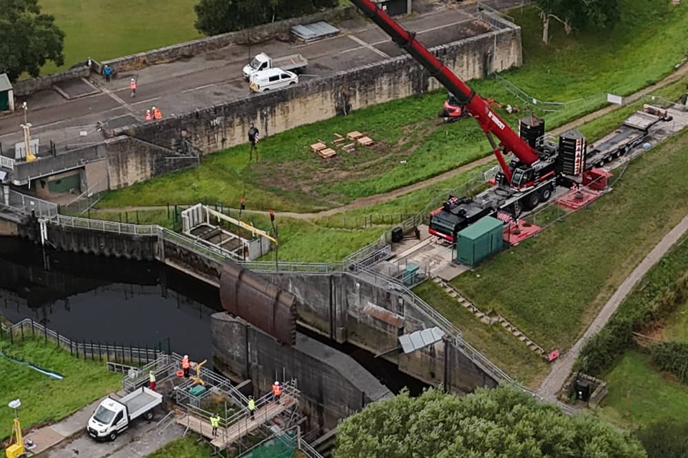 A reinforced crane lifted the broken floodgate out of the river on Tuesday