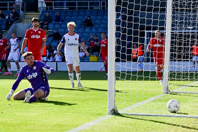 Luca Thomas scores Fylde’s second of the game - the Worthing keeper Taylor Seymour can't help but watch his shot go home.