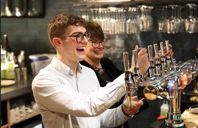 Declan serves customers inside his bar.