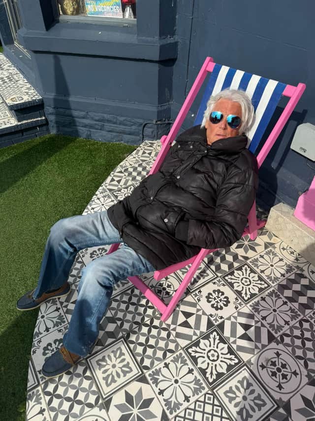 Ephraim Bell relaxes outside his hotel.
