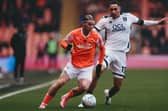 Josh Bowler under pressure from Jon Russell during Blackpool's defeat to Mansfield Town at Bloomfield Road