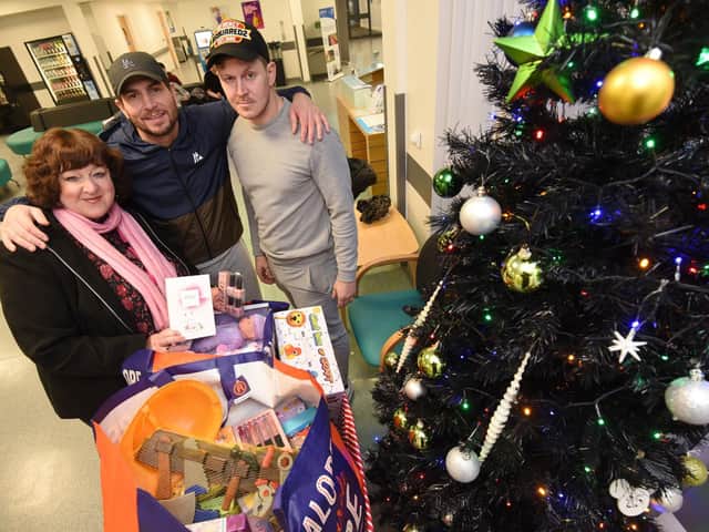 Brian Rose and Dan Coyle of BR Boxing and Fitness present Christmas gifts to Elaine Walker at Blackpool Victoria Hospital