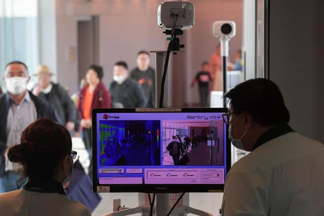 Health officers screen arriving passengers from China with thermal scanners at Changi International airport in Singapore on January 22, 2020 as authorities increased measure against coronavirus (Photo by ROSLAN RAHMAN / AFP)