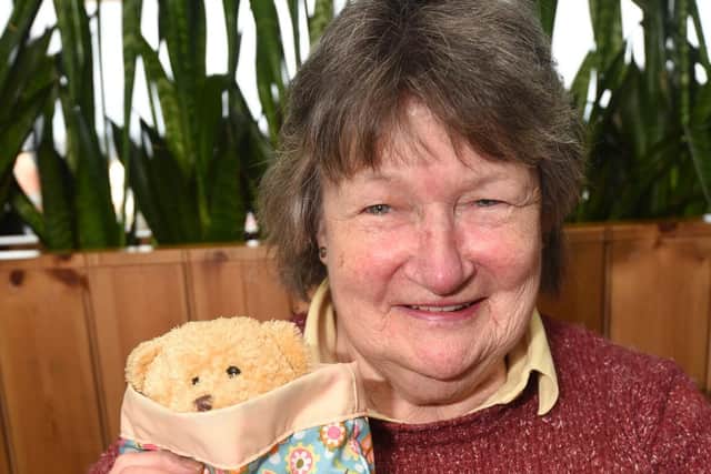 Brenda Cross with one of the Joey pouches she has knitted to be sent to Australia.