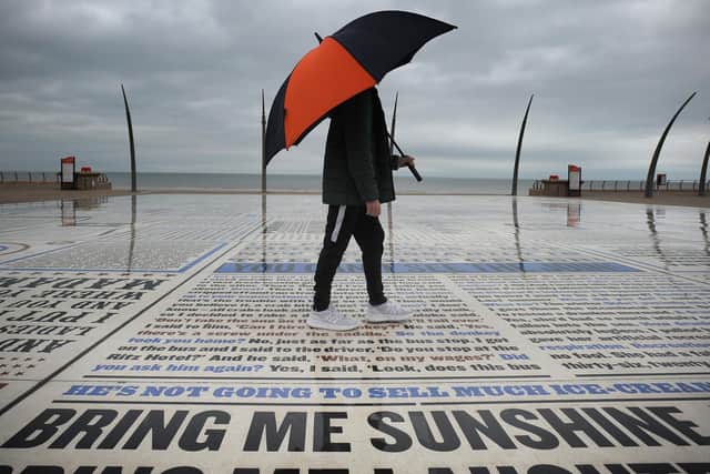 A man with an umbrella walks across Blackpool's Comedy Carpet in April 2018 (Picture: Daniel Martino for JPIMedia)