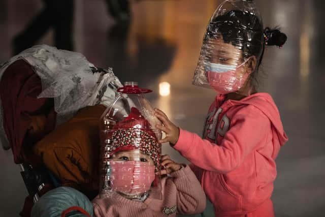 Chinese children wear plastic bottles as makeshift homemade protection and protective masks while waiting to check in to a flight at Beijing Capital Airport 
(Kevin Frayer/Getty Images)