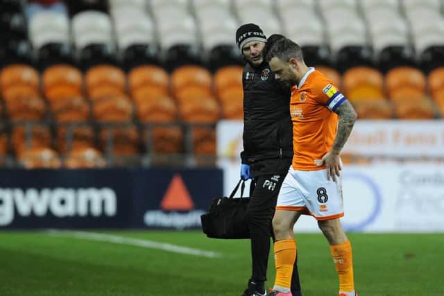 Jay Spearing leaves the pitch after receiving treatment from physio Phil Horner