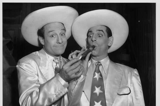 Portrait of comedy duo Jimmy Jewel and Ben Warriss, in costume and lighting a cigar, circa 1940. Photo: Getty Images