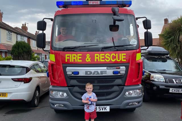 Leo White, three, posing in front of the fire engine