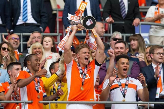 Goalscorer Brad Potts lifts the League Two play-off trophy after Blackpool's Wembley win over Exeter City