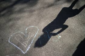 Shadows of children of key workers falls on their chalk drawings (Photo by Christopher Furlong/Getty Images)