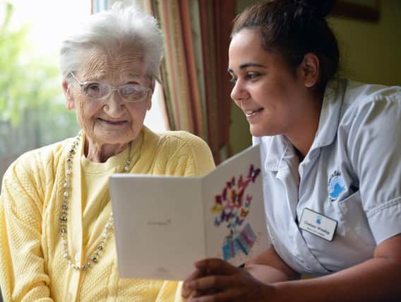 Jessie McQuillan reading a birthday card on her 104th birthday with senior care assistant Chelsea Winship. Picture by Frank Reid.