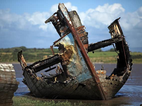 The boats sit derelict, rotting away on the banks of the River Wyre