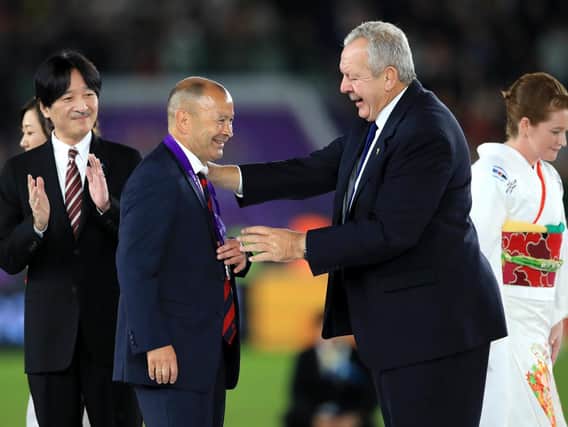 Sir Bill Beaumont presents England head coach Eddie Jones with his runners-up medal after last year's Rugby World Cup final in Japan