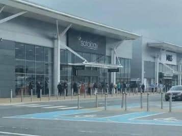 Shoppers queue to get into the Marks and Spencer food hall in Deepdale today.