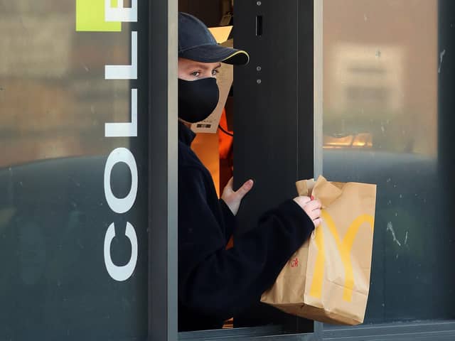 An employee wears a mask to serve customers at a McDonald's drive-thru