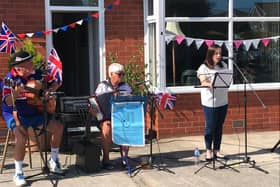 Elizabeth Singleton sings with Chris and Will Lingardduring the VE day outdoor performance