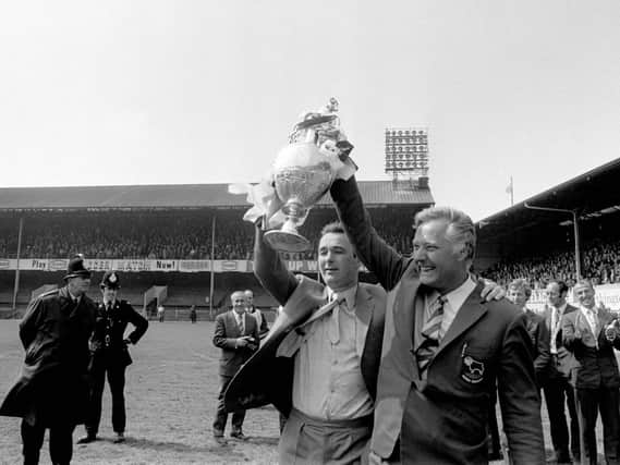 Derby County manager Brian Clough (left) and his assistant Peter Taylor show off the League Championship trophy to the jubilant Derby fans who had packed the Baseball Ground in 1972