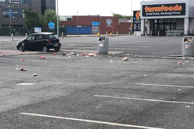 Dozens of red and white cartons from the fried chicken chaincan be seen strewn across the car parkon Devonshire road. (Photo by Joanne Musik)