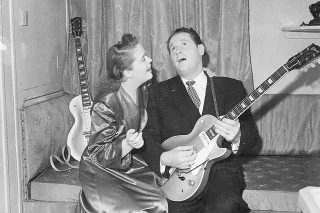 Popular guitarist Les Paul serenades his wife and singing partner Mary Ford. Photo: Getty Images