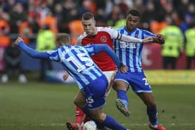 Paul Coutts is sandwiched by Blackpool players in Fleetwood's final home game before the lockdown