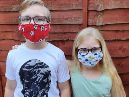 Layla and Fletcher Rider model the facemasks which Wendy Radcliffe and Kerry Dewhurst are making to help Trinity Hospice