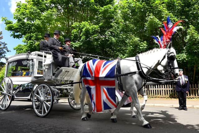 The horse-drawn hearse carrying former Royal Marine Commando Derek Coyle to his final rest