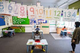 Children and teacher maintain social distancing measures while they take part in lessons