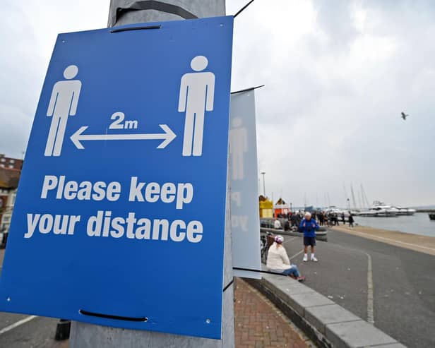 Signs ask visitors to adhere to the British government's current social distancing guidelines and stay two meters apart