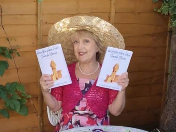 Linda Hampton with copies of her book