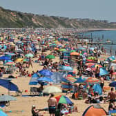 Beachgoers enjoy the sunshine as they sunbathe and play in the sea on Boscombe beach in Bournemouth (Photo by GLYN KIRK/AFP via Getty Images)