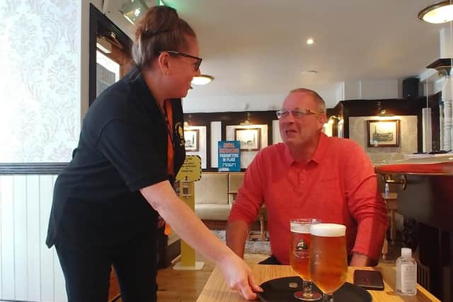 Landlady Kerry Humphries serves a customer at The Mitre