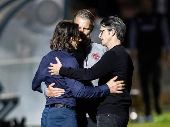Wycombe boss Gareth Ainsworth embraces Fleetwood head coach Joey Barton and his assistant Clint Hill.