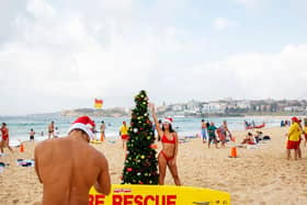 Italians pose for a photograph in front of a Christmas tree at Bondi Beach on December 25, 2019 in Sydney, Australia