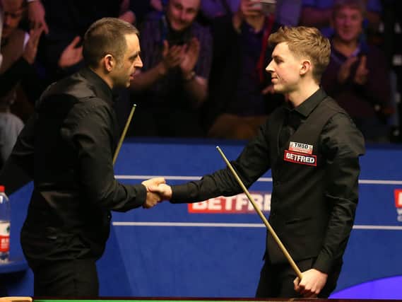 James Cahill (right) shakes hands with Ronnie O'Sullivan after the ultimate upset at last year's World Snooker Championship