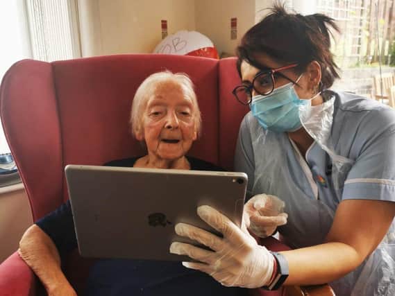 Carer Pam Brown helping Maureen Jackson to use an iPad to ring her granddaughter and great grandchildren