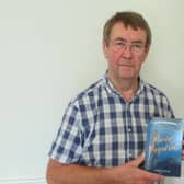 Nigel Hanson with a copy of his debut novel