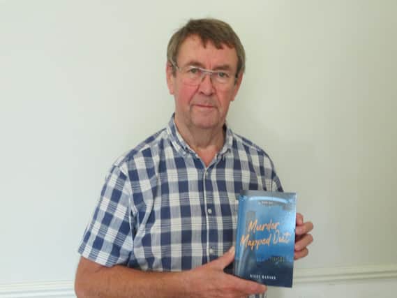 Nigel Hanson with a copy of his debut novel