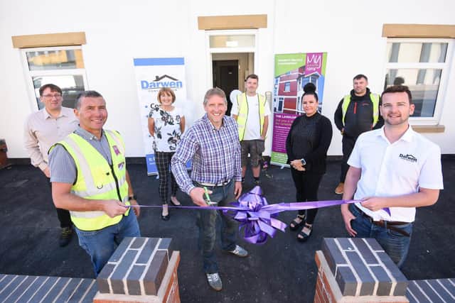 A former coach house on George St has been turned into apartments by builder Arron Darwen (right) and Blackpool Housing Company. David Galvin (centre) from Blackpool Housing Company cuts the ribbon