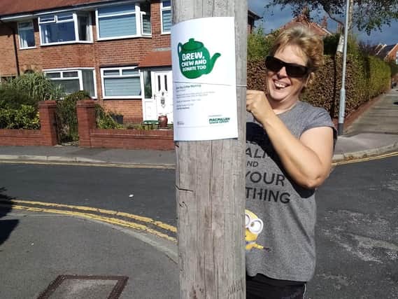 Sam Mcwhinnie is pictured putting up one of the posters for the coffee morning on Birch Way, Poulton